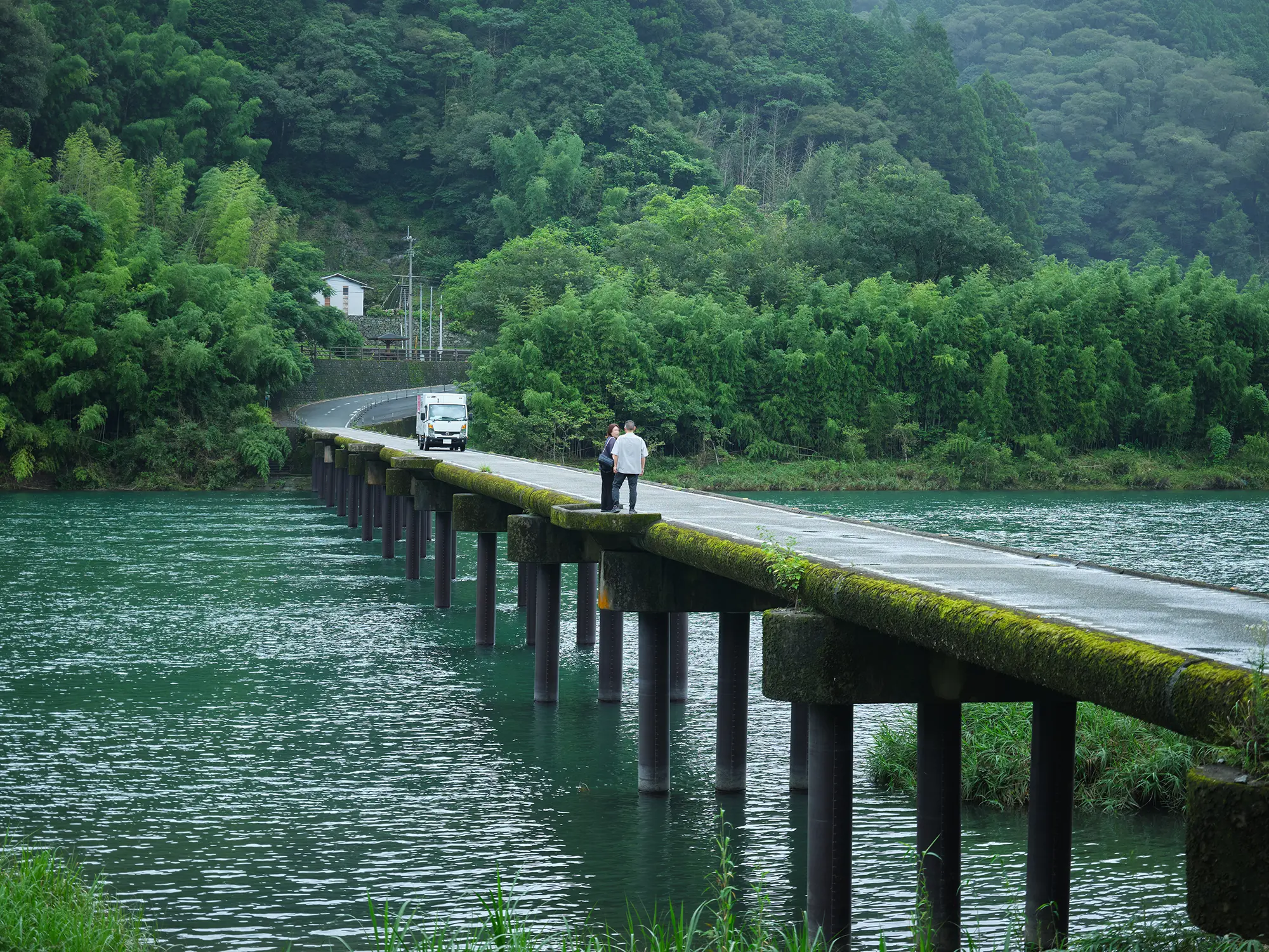 川沿いの道を進む人